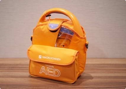 画像：AED（自動体外除細動器）突然の心停止（心臓突然死）から命を救うための装置です。相鉄フレッサインは人命を尊重して全ホテルのフロントに設置しております。ご宿泊に関係なくどなたでもご利用いただけます。